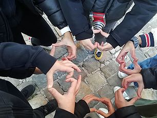 Bambini in cerchio che formano cuori con le mani